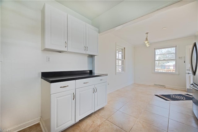 kitchen featuring light tile patterned floors, visible vents, dark countertops, and white cabinetry