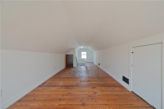 bonus room with lofted ceiling and hardwood / wood-style flooring