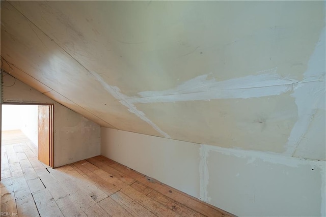 bonus room with light wood-style flooring and lofted ceiling