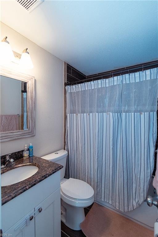 full bathroom featuring vanity, curtained shower, toilet, and visible vents