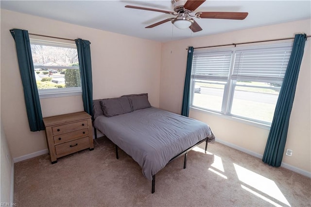 carpeted bedroom featuring ceiling fan and baseboards