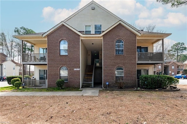 view of front of property with stairway and brick siding