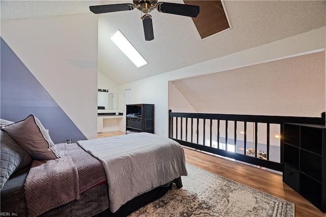 bedroom featuring a textured ceiling, a ceiling fan, lofted ceiling, and wood finished floors