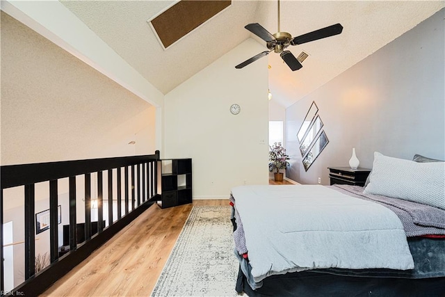 bedroom with vaulted ceiling, a ceiling fan, and wood finished floors