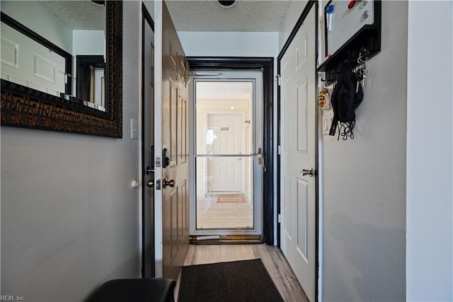 doorway featuring a textured ceiling and light wood-style flooring