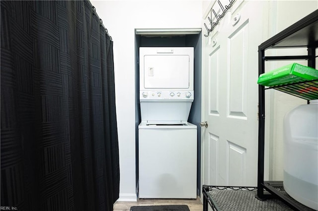 laundry room featuring laundry area, stacked washer and clothes dryer, and light wood-style floors