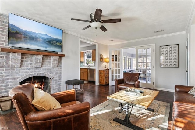 living area featuring baseboards, a brick fireplace, crown molding, and hardwood / wood-style flooring