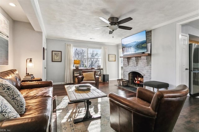 living area with a brick fireplace, wood finished floors, baseboards, and ornamental molding