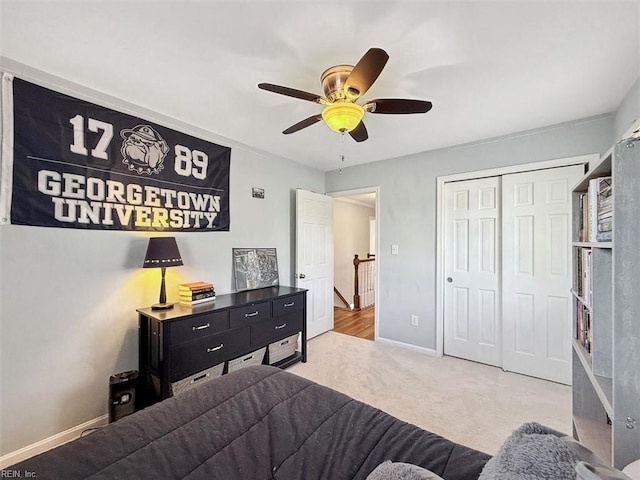 carpeted bedroom with a closet, ceiling fan, and baseboards