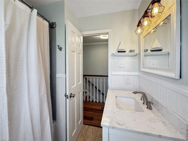 full bathroom featuring vanity, shower / tub combo, wood finished floors, and a wainscoted wall