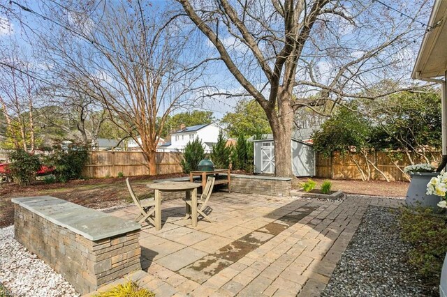 view of patio / terrace with a storage unit, an outbuilding, and a fenced backyard