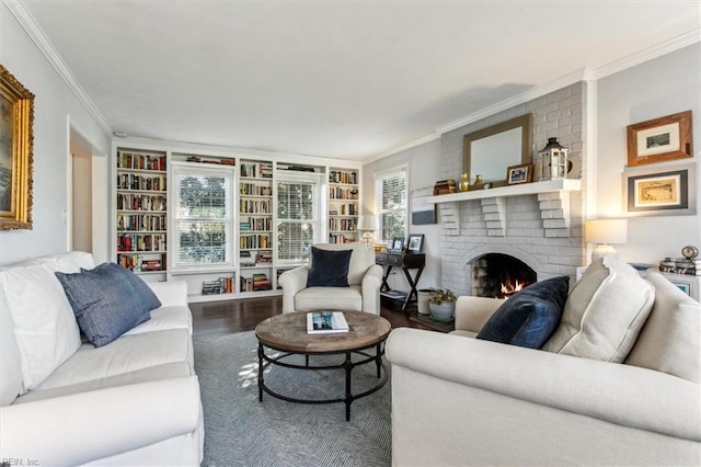 living area with a fireplace, crown molding, built in shelves, and wood finished floors