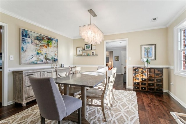 dining space featuring a chandelier, crown molding, dark wood-type flooring, and baseboards