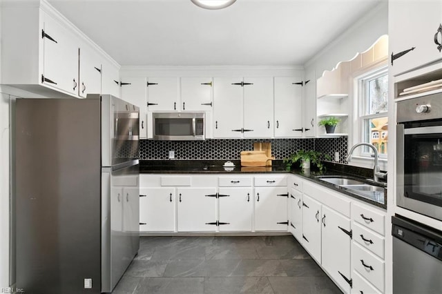 kitchen featuring a sink, open shelves, dark countertops, appliances with stainless steel finishes, and decorative backsplash