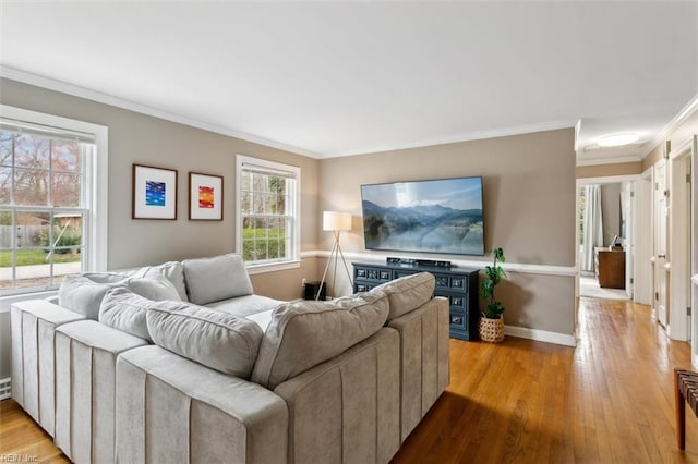 living area with crown molding, baseboards, and wood finished floors