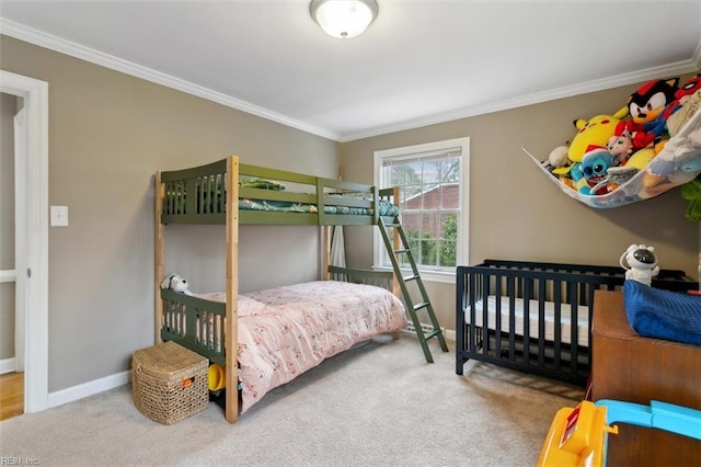 carpeted bedroom featuring crown molding and baseboards