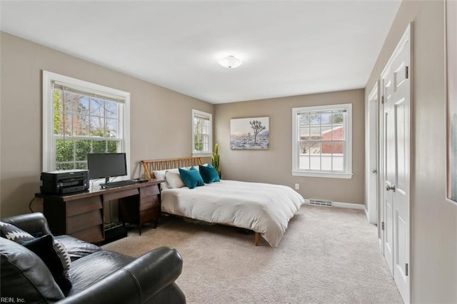 carpeted bedroom with multiple windows, baseboards, and visible vents