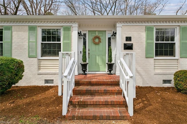 doorway to property with crawl space and brick siding