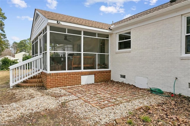 back of house featuring brick siding, roof with shingles, a sunroom, crawl space, and a patio