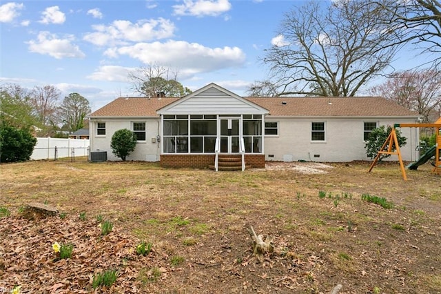 back of property featuring fence, a playground, a yard, a sunroom, and crawl space