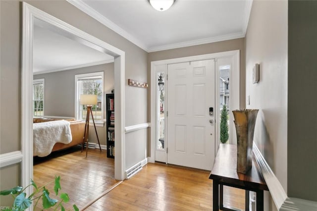 entrance foyer featuring visible vents, baseboards, crown molding, and light wood-style floors