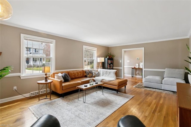 living room featuring wood finished floors, visible vents, a wealth of natural light, and ornamental molding