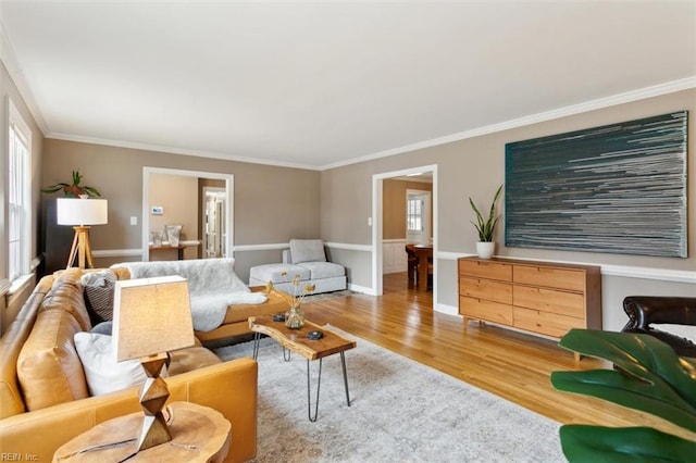 living room with baseboards, wood finished floors, and crown molding