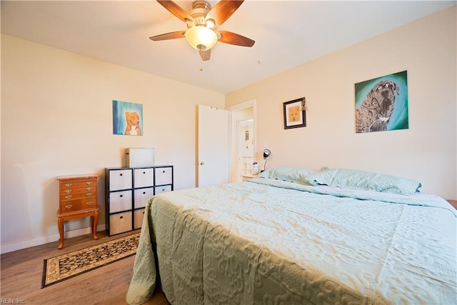 bedroom featuring a ceiling fan, wood finished floors, and baseboards