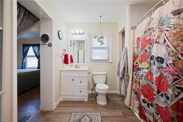 full bath with vanity, toilet, wood finished floors, and visible vents