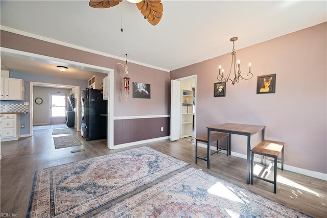 dining area featuring baseboards, wood finished floors, a ceiling fan, and ornamental molding