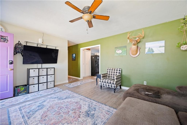 interior space featuring ceiling fan, baseboards, and wood finished floors