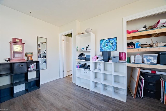 misc room with baseboards and wood finished floors