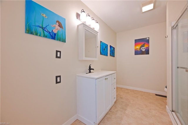 full bath featuring a shower with shower door, baseboards, and vanity