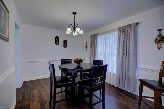 dining space with wood finished floors and a chandelier