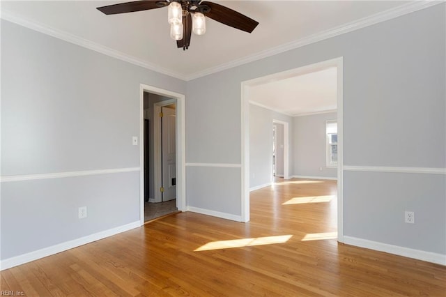 empty room with light wood finished floors, a ceiling fan, baseboards, and ornamental molding