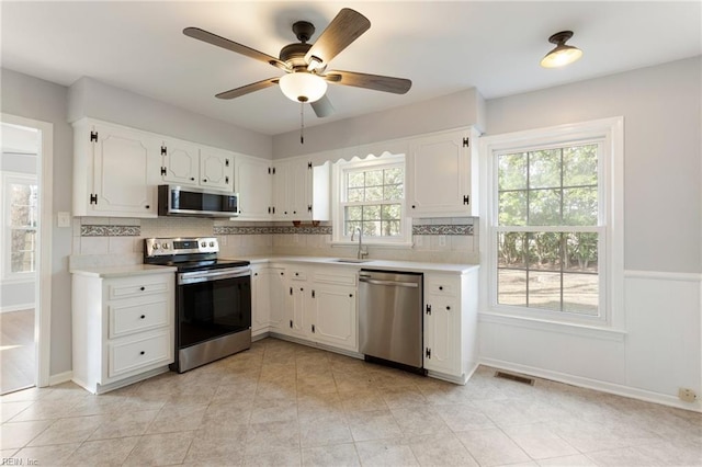 kitchen with visible vents, white cabinets, stainless steel appliances, and light countertops