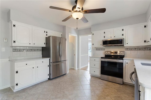 kitchen with white cabinetry, light countertops, decorative backsplash, and stainless steel appliances