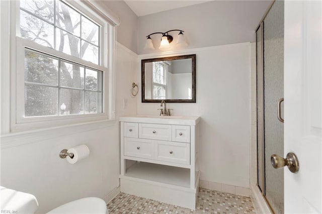 bathroom with toilet, a stall shower, and vanity