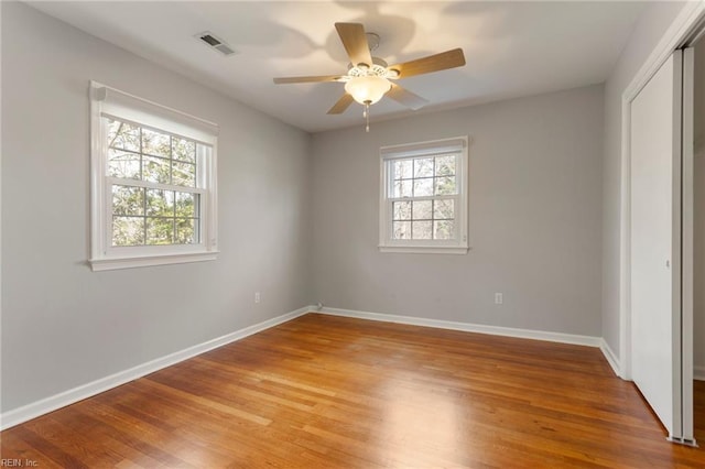 unfurnished bedroom featuring light wood finished floors, visible vents, ceiling fan, baseboards, and a closet