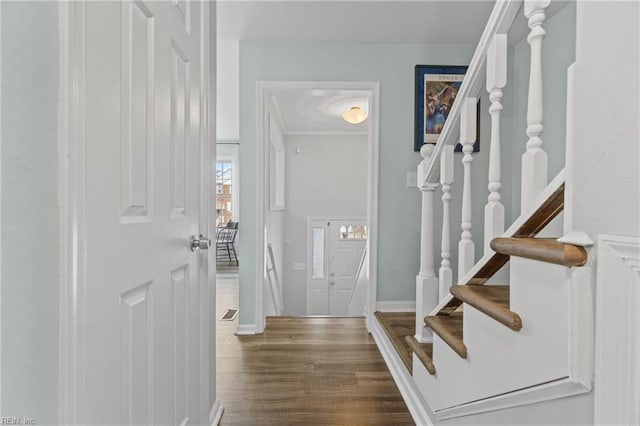 foyer entrance with stairs, wood finished floors, and baseboards