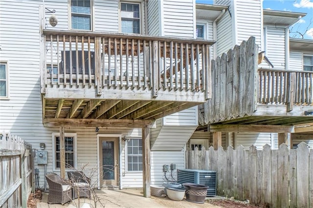 wooden deck with a patio area, fence, and central AC