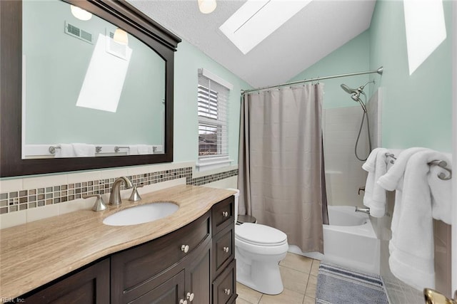 full bathroom with tile patterned flooring, visible vents, lofted ceiling with skylight, toilet, and vanity