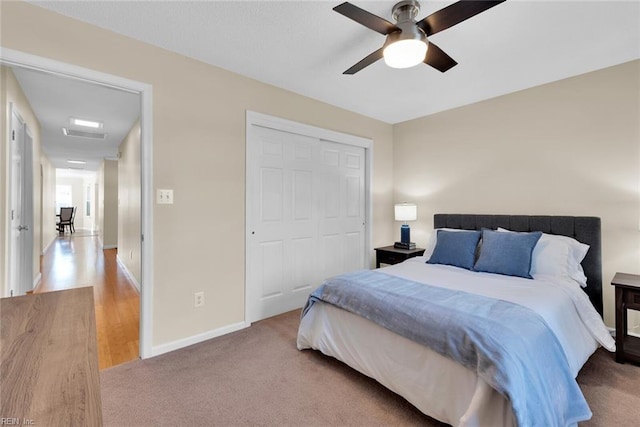 carpeted bedroom featuring a ceiling fan, baseboards, and a closet