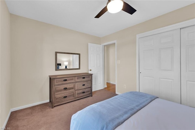 carpeted bedroom with a ceiling fan, baseboards, and a closet