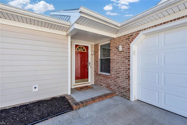 doorway to property featuring brick siding and an attached garage