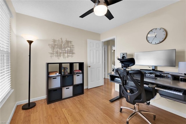 office area with light wood-style flooring, baseboards, and a ceiling fan