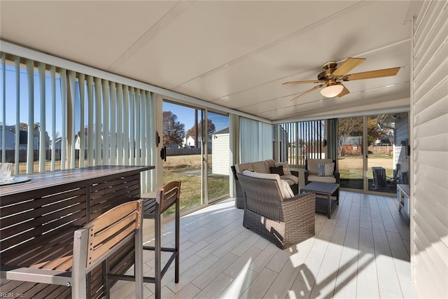 sunroom / solarium featuring a ceiling fan