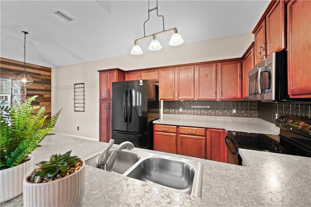 kitchen with black appliances, pendant lighting, a sink, tasteful backsplash, and wood walls