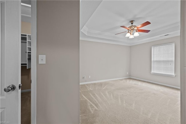 unfurnished room featuring crown molding, a raised ceiling, ceiling fan, and carpet floors