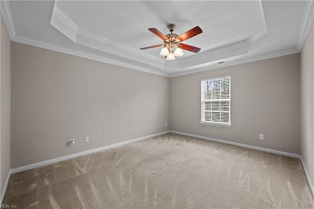 carpeted empty room featuring a tray ceiling, baseboards, visible vents, and ceiling fan